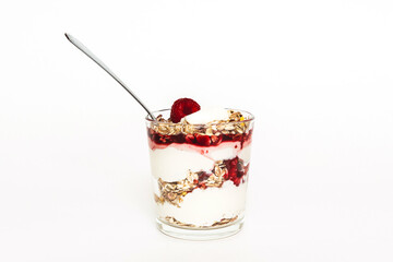Muesli with raspberries and yogurt in a glass with a spoon.