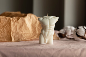 Fototapeta na wymiar Candle in the form of a naked male body. Handmade scented candles.
