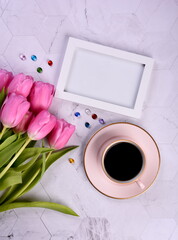 Purple tulips, coffee mug, white photo frame, laptop,  gemstone crystals, copy space