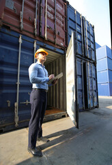 Engineer or supervisor checking and control loading Containers box from Cargo at harbor.Foreman...