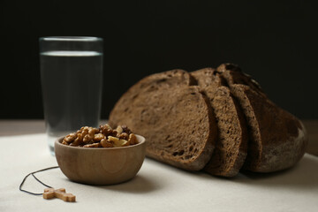 Bread, walnuts, water and crucifix on table. Great Lent season