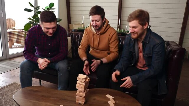 A company of guys playing a board game, fun time at home. High quality FullHD footage