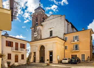 Fototapeta na wymiar February 12, 2021 - Castel San Pietro Romano, Lazio, province of Rome, Palestrina - The small medieval village. The Church of San Pietro with the bell tower and the clock, in the cobbled square.