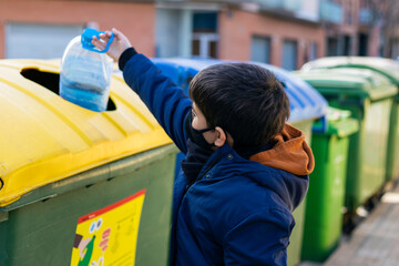 Child recycling plastic containers in the corresponding container.
Conceptual of caring for the...