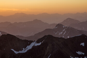 layered mountain ranges in golden sunrise light in switzerland grisons engadin