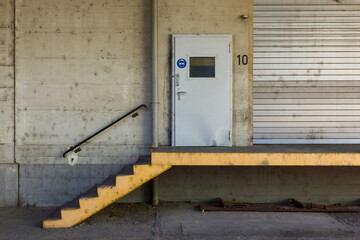 delivery bay entrance in industrial building with door and stairs leading up to it