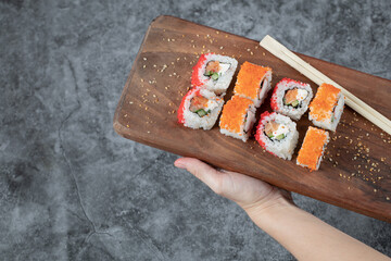 Sushi rolls with red caviar on a wooden board