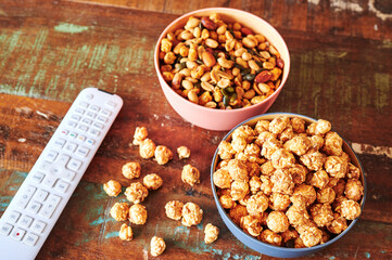Wooden table with snacks and a TV remote control.
