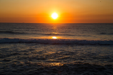 Fototapeta na wymiar Puesta de sol con colores amarillos y naranjas sobre el Océano Atlántico en Esmoriz (Portugal)