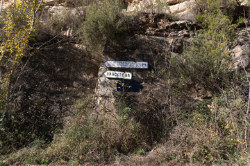 Two road signs showing the way to Barcelona and the Monastery of Sant Miquel del Fai in Catalonia, Spain