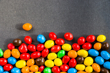 M&M's candy on the black background, colorful candy, multicolored gradient