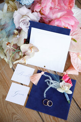 Wedding details. envelope, invitation, wedding rings and a bouquet of flowers