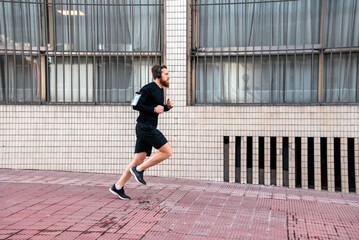 Fototapeta na wymiar Young Man Running in the Street
