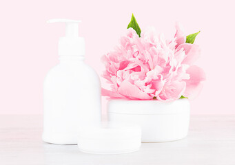 Obraz na płótnie Canvas Composition with natural skincare products and peony flower on a pale pink background. Soft focus. Bio organic product. Beauty and spa concept.