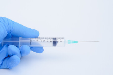 Doctor holds disposable syringe for vaccination on white background.Covid vaccine.
