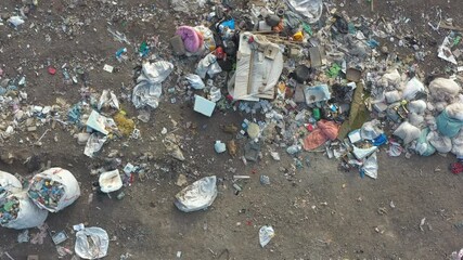 Aerial shot of rubbish pile lying among countryside. Flying over huge dump trash with plastic and other industrial waste. Global environmental pollution problem. Ecological disaster. Top view