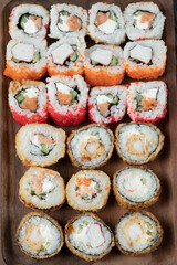 Sushi set isolated on a wooden board on black background