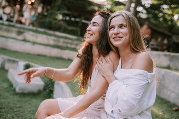 Naklejka premium Female couple sitting in a park and hugging