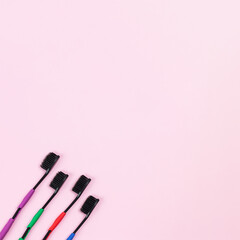 Eco tooth brushes made of biodegradable plastic and bamboo active charcoal bristle on pink background