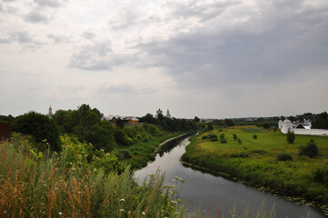 Panoramic views of the river, green fields and churches. Rural landscape.