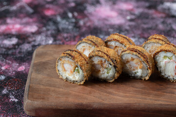 Fried hot rolls on a wooden board with crispy cover
