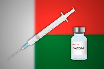 Syringe and vaccine vial on blur background with Madagascar flag,