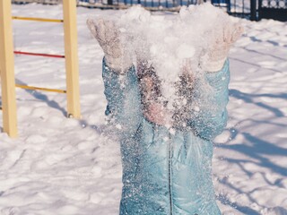 Happy young woman throwing snow in the air. Winter Holidays concept.