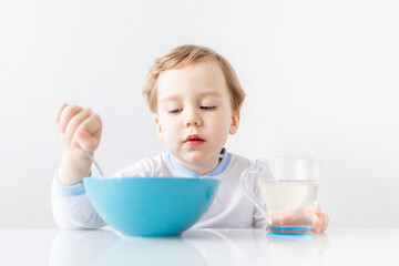baby boy eats with a spoon at home, the concept of food and nutrition for children