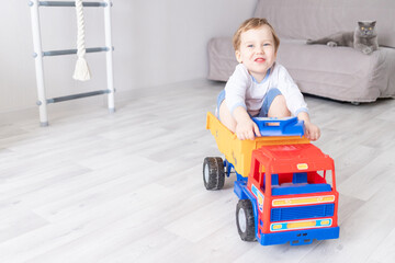 baby boy sitting or riding in a typewriter at home, the concept of a child's game