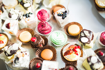 Delicious and tasty dessert table with cupcakes shots at reception closeup