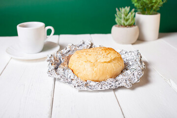 Minimalism, food on a background. Empty text space, mocap. Hot breakfast bun. Green flowers, eco-friendly.