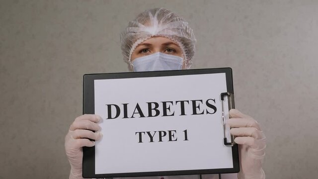 Close-up of a female doctor in a medical uniform holding a sign that says TYPE 1 DIABETES.