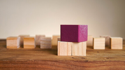 Wooden block surrounding purple block. Leadership, teamwork concept.
