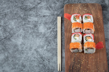Sushi rolls with seafood and red caviar isolated on a wooden platter