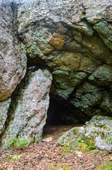 Small cave entrance shaped by granite rocks.