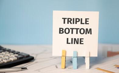 Bottom Line on a sticker beside a calculator and a pen. Finances and business concept.