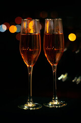 two glasses of pink champagne amid the lights of the night city. High quality photo
