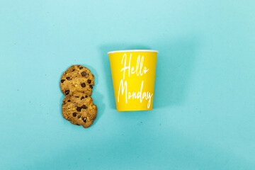 chocolate cookies and hello monday on disposable cup isolated on blue background