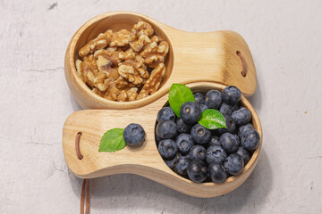 Walnuts and fresh blueberries in a wooden mug. Natural vitamins concept