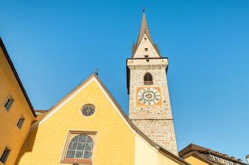 Fototapeta na wymiar Bell tower of the Ursulinen Holy Saviour church in the historic city of Bruneck or Brunico, South Tyrol, Italy