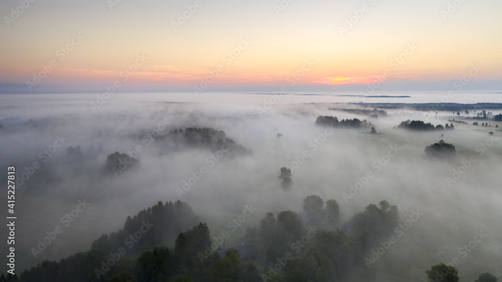 Wall mural aerial shot of beautiful karula national park full of lakes in estonia on a foggy morning