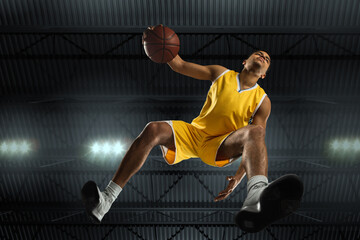 Young professional basketball player in action, motion isolated on black background, look from the...