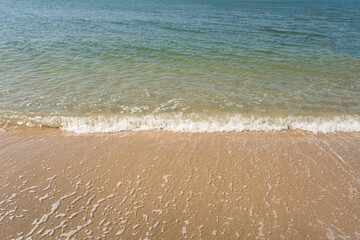 Soft ocean wave of blue ocean on tropical sandy beach in summer background with copy space. texture Background