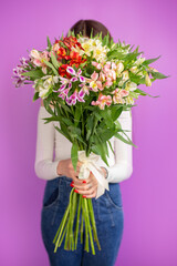 The girl with big bouquet of flowers in front of her