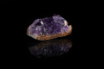Beautiful amethyst druse close-up on black glass background. Semi precious gem used for jewels.
