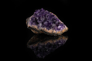 Beautiful amethyst druse close-up on black glass background. Semi precious gem used for jewels.