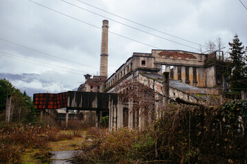 Overgrown ruins of industrial building. Abandoned, destroyed by war power plant in Tkvarcheli Tquarhcal, Abkhazia, Georgia
