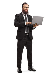 Full length portrait of a bearded businessman standing and using a laptop