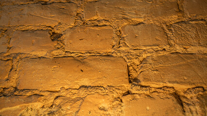 Brick wall illuminated with yellow light.