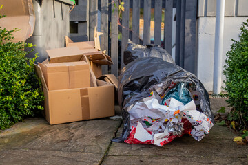 Christmas household waste consisting of boxes and wrapping paper at a trash can